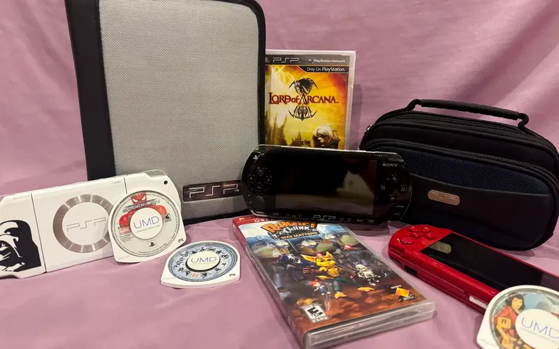 Sony PSP handhelds in black, white and red, with UMD games, movies and carrying cases